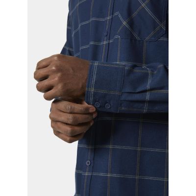 Helly Hansen Men’s Aker Flannel Long Sleeve Shirt. Med en regelmæssig pasform, justerbare manchetter og darts på bagsiden af skuldrene til forbedret mobilitet. Den er udstyret med en praktisk brystlomme og knappet front.